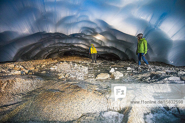 Abenteuerlustiges Paar erkundet eine Eishöhle.