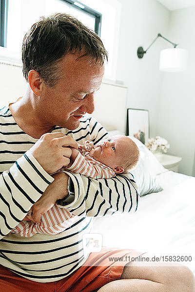 Closeup portrait of a dad holding his newborn daughter