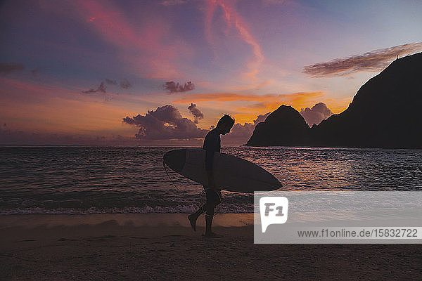 Surfer am Strand zur Zeit des Sonnenuntergangs