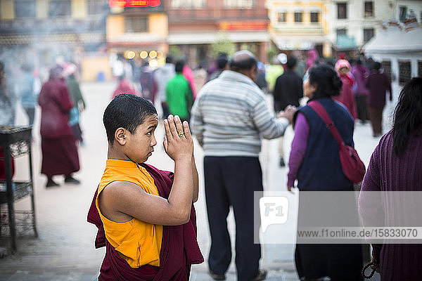 A young monk prays at Boudhanath Stupa in Kathmandu  Nepal.