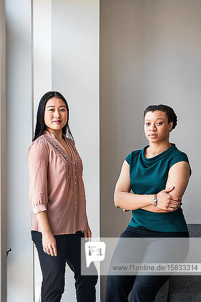 Porträt selbstbewusster Kolleginnen gegen die Wand im Büro