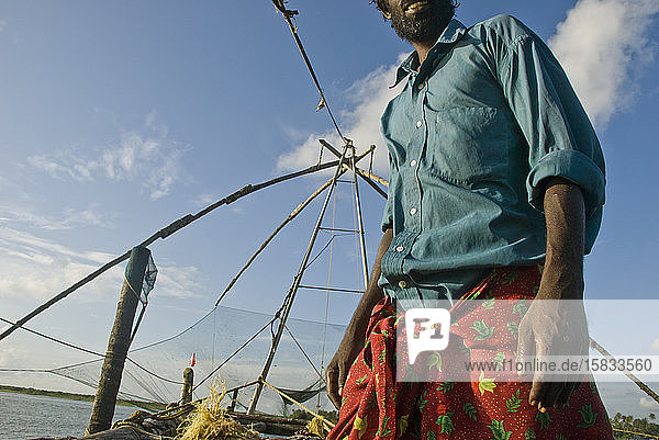 Fischer in der Bucht von Fort Kochi in der Nähe chinesischer Fischernetze
