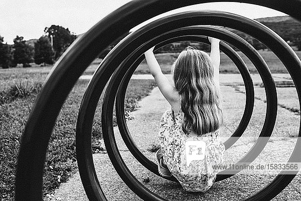 Ein kleines Mädchen sitzt in einem spiralförmigen Fahrradträger.