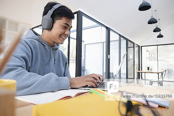 Junger Collagestudent studiert mit Computer und Mobilgerät