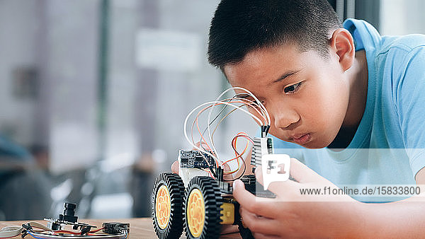 Konzentrierter Junge schafft Roboter im Labor.