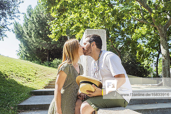 Junges Paar küsst sich auf einem Park