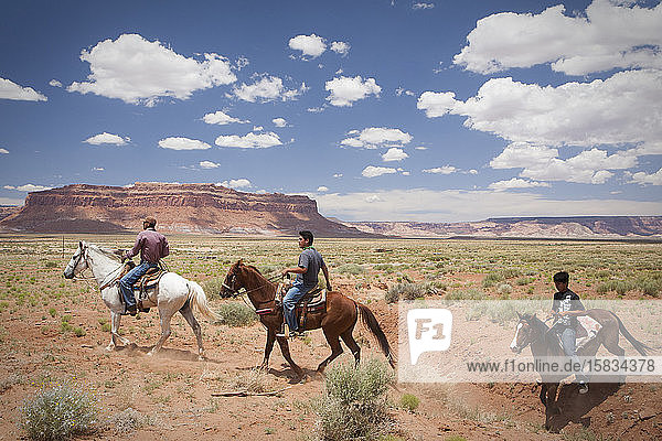 Reiter durchqueren eine Ebene in der Nähe des Monument Valley  Arizona