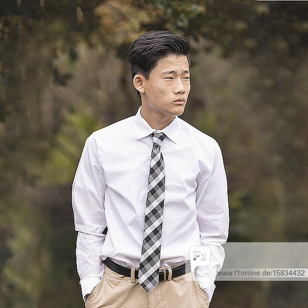 Asiatisch-chinesischer Teenager in weißem Hemd  Krawatte und khakifarbener Hose