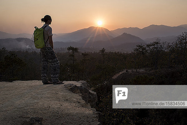 Silhouette einer jungen Wanderin beim Betrachten des Sonnenuntergangs am Pai Canyon (Kong Lan)  Nordthailand.