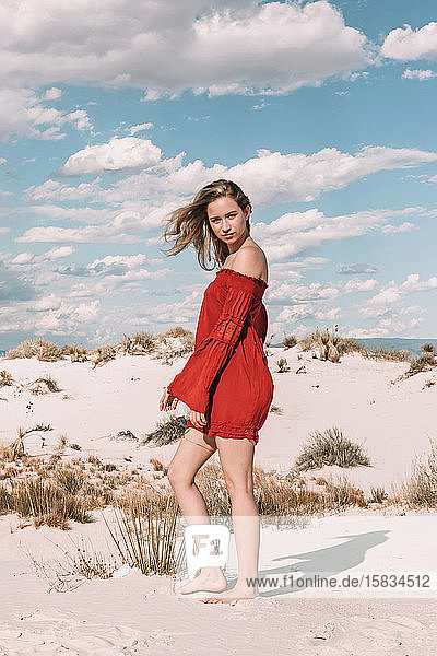 zwanzig-irgendwas Frau im roten Kleid in der Wüste