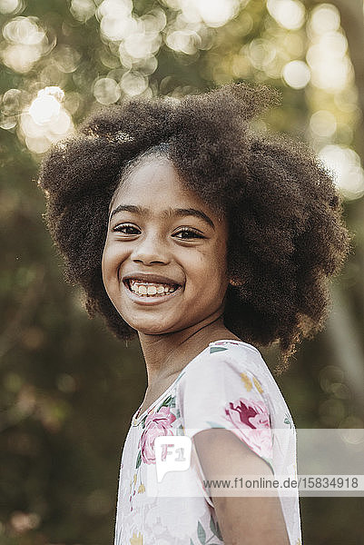Close up portrait of young school-aged confident girl smiling at