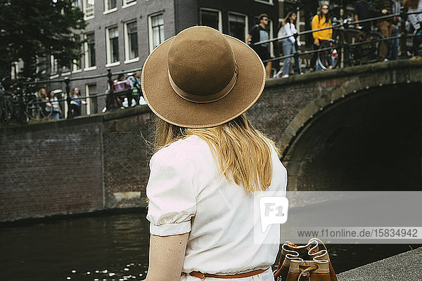 Frau mit Hut mit Blick auf Kanal und Stadt