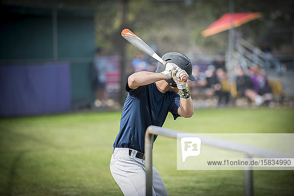teen baseball player ready to hit in the on deck circle