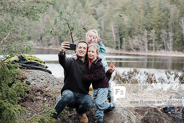 Vater fotografiert mit seinen Kindern beim Wandern in Schweden