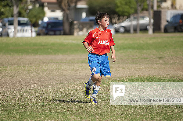 Young soccer player jogging on the field during a game