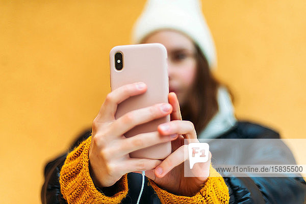 Junge attraktive Frau  die sich mit einem Smartphone fotografiert