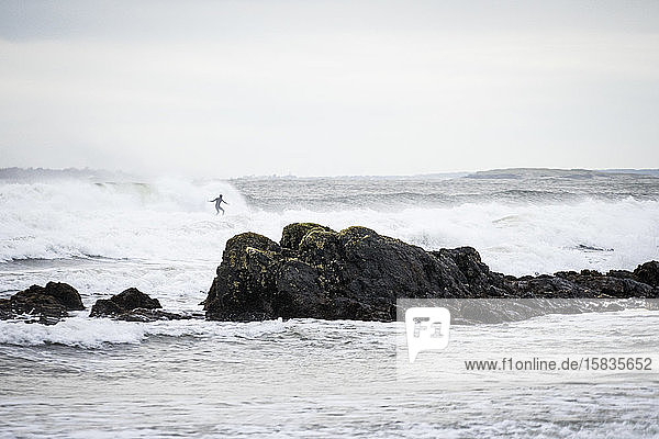 Surfer catching a wave off the coast of Maine