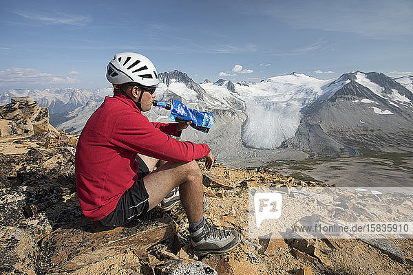 hiker drinking filtered water on mountain summit.