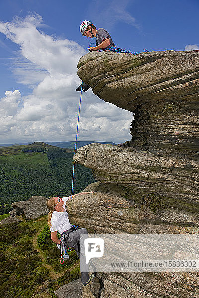two friends are climbing at Stanage edge in the Peak District