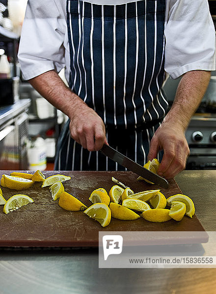 Chefkoch hackt frische Zitrone in einem Restaurant in Großbritannien