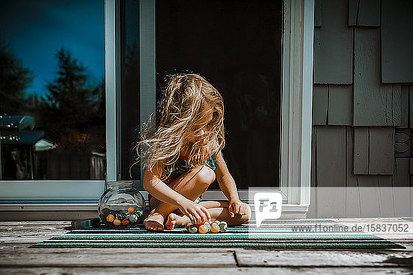 4-jähriges Mädchen spielt an einem Sommertag mit einem Gummiball