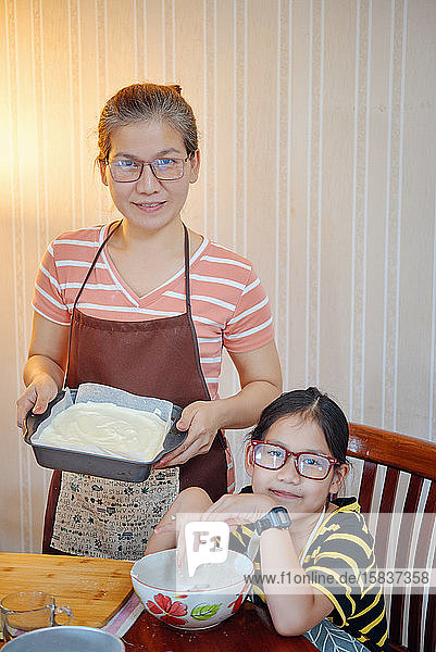 Mutter und Tochter mit Kuchen im Backblech