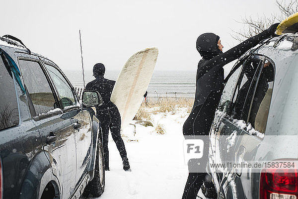 Frauen bereiten sich an einem verschneiten Tag auf das Surfen vor