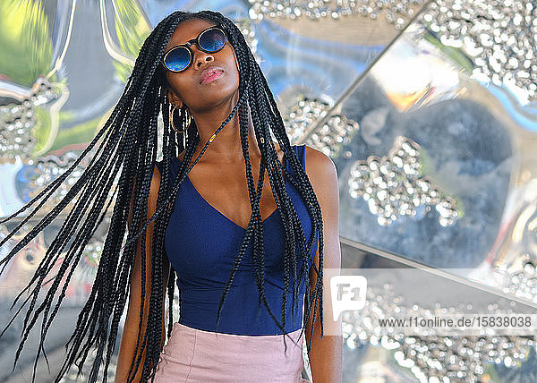young black woman with very long braids and very attractive and sensual enjoying barcelona in summer and doing model with mobile  glasses and camera  technology concept.