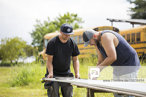 Zwei Männer arbeiten an der Montage von Sonnenkollektoren.