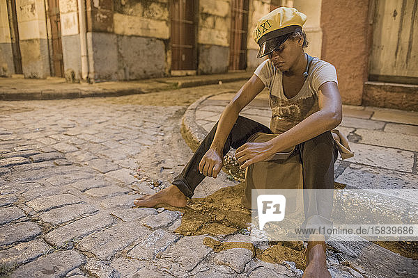 Homeless woman wearing a taxi cap in the streets of Sao Luis