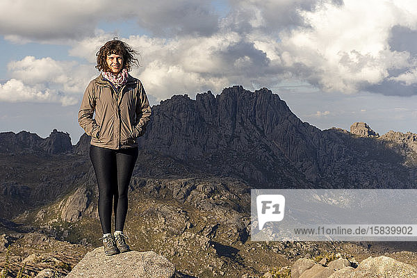 Frau auf schöner Landschaft mit Höhenfeldern und felsigen Bergen