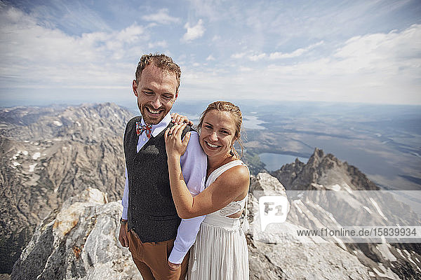 Jungverheiratete halten sich nach der Heirat auf einem Berg fest