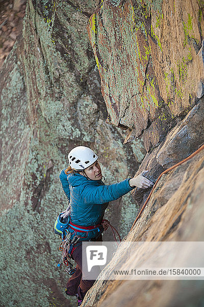 Woman chalks hands while rock climbing in Eldorado Canyon  Colorado