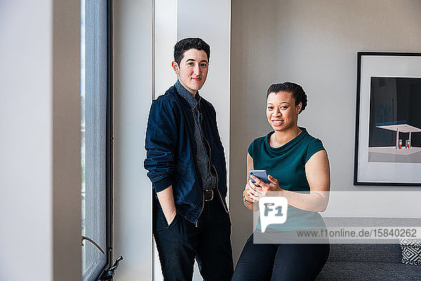 Porträt selbstbewusster männlicher und weiblicher Kollegen gegen die Wand im Büro