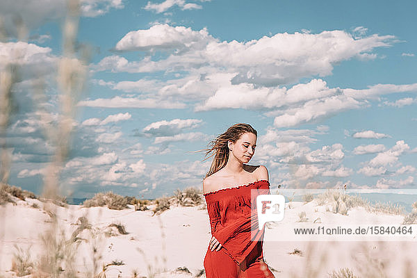 zwanzigjährige Frau in einem roten Kleid in der Wüste