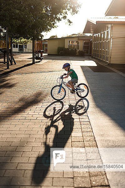 Junge fährt Fahrrad mit Schatten