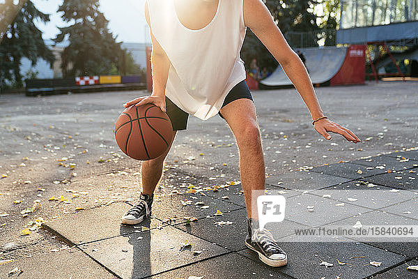 Men with curvy hair play basketball outdoors  close up