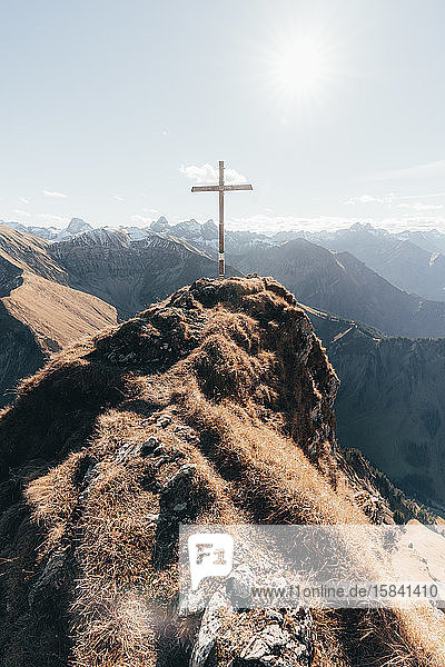 Gipfel mit Kreuz in deutschen Alpen gegen blauen Himmel