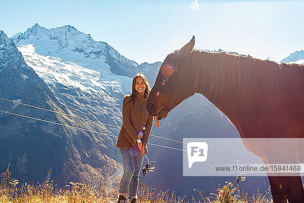 Girl traveler with a horse in the background of mountains