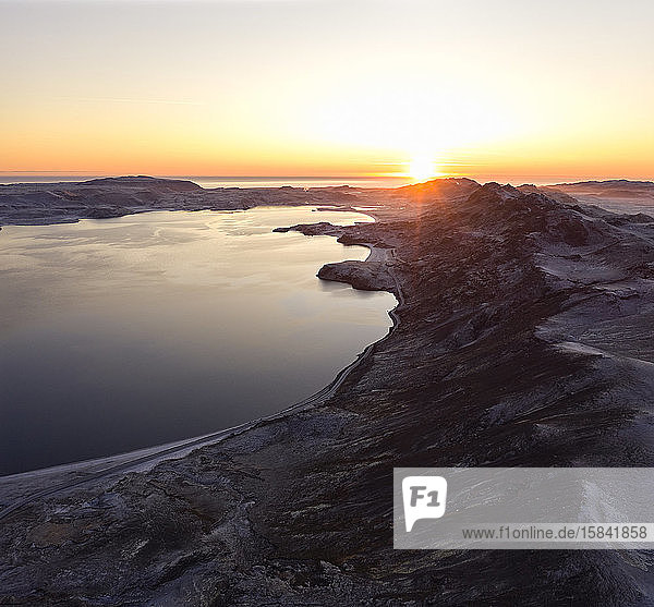 Wunderschöner Sonnenuntergang über steinigem Ufer