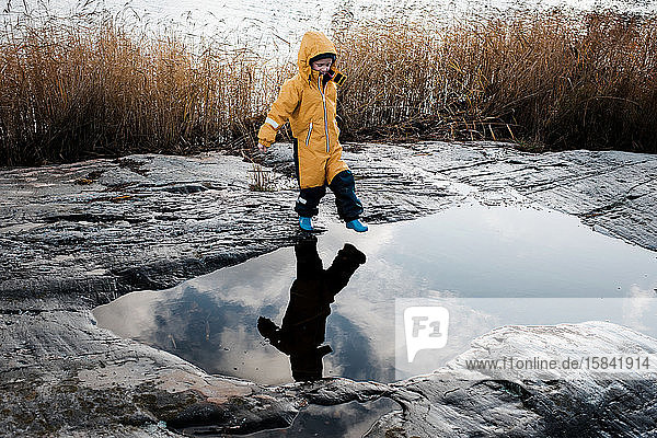 boy and his reflection jumping over water on an island in Sweden