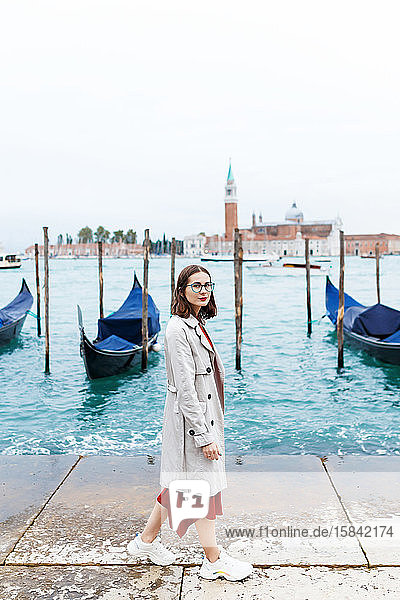 junger Tourist in Kleid und Mantel auf Kanal- und Veneziagondel