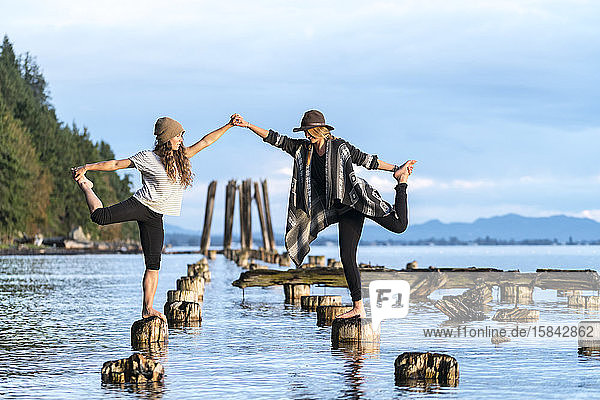 Zwei Frauen machen Yoga auf den Überresten eines alten Piers in Bellingham  WA