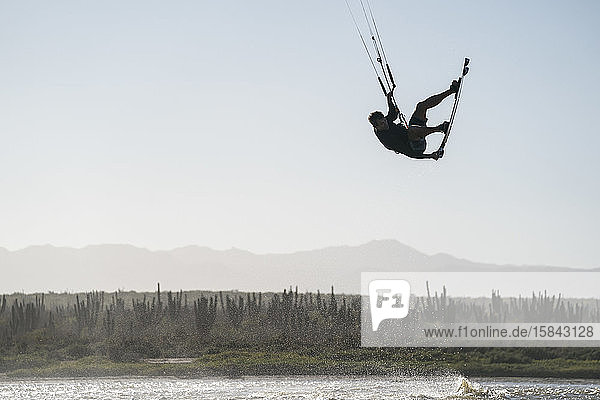 Professioneller männlicher Athlet beim Kitesurfen an einem sonnigen Tag in Mexiko