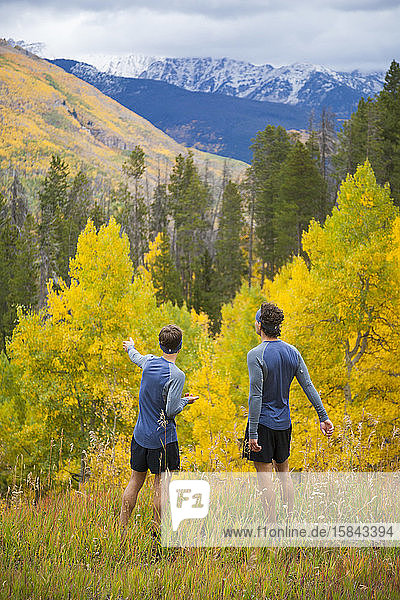 Men on trail run enjoy view of aspen and mountains in Vail  Colorado