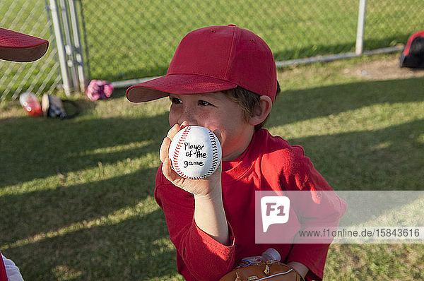 Junge hält seinen Spieler des Spiels Baseball auf dem TBall-Feld