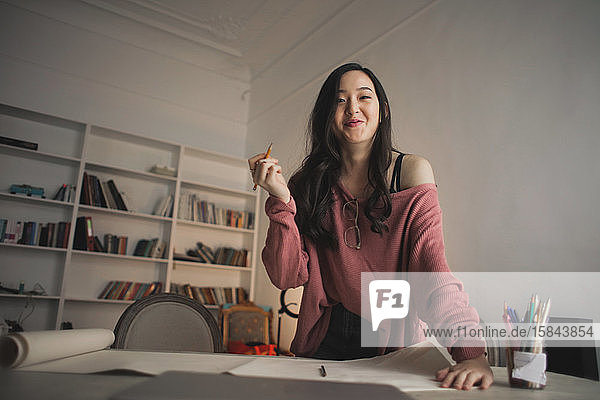 Lächelnde asiatische Frau in einem kreativen Studio