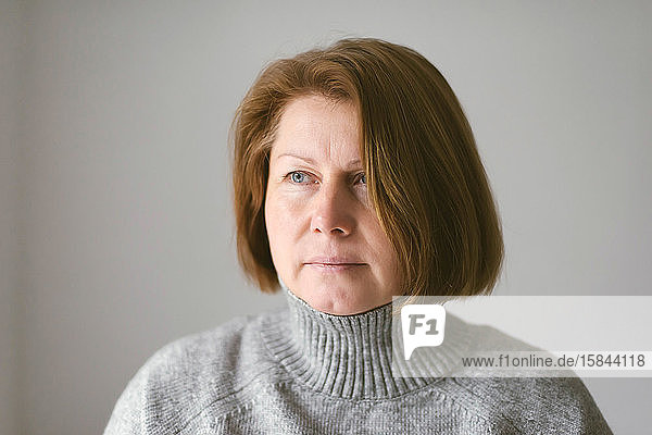 Erwachsene Frau mit kurzen braunen Haaren vor weißem Hintergrund