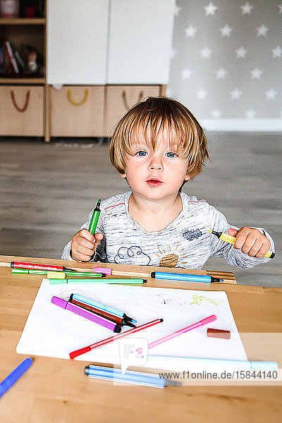 Kleiner Junge zeichnet mit Filzstiften