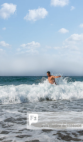 Mann wärmt sich in den starken Wellen Griechenlands im Sommer auf